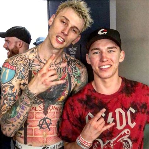 Two Men Standing Next To Each Other With Tattoos On Their Arms And