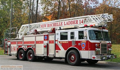 A Red And White Fire Truck Parked On The Side Of The Road In Front Of