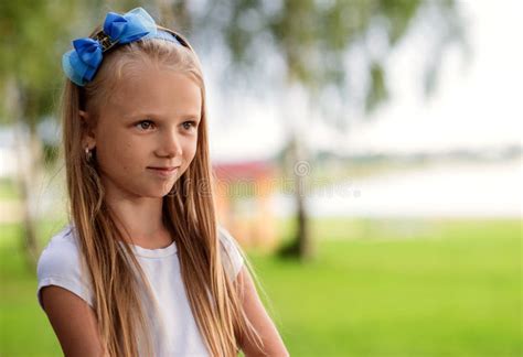 La Belle Petite Fille Avec De Longs Cheveux Tient Des Fleurs Dehors