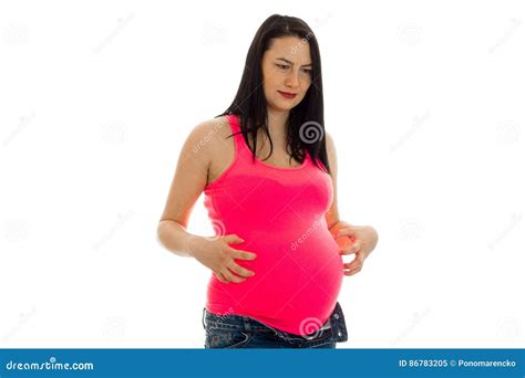 Cute Brunette Pregnant Woman In Bright Pink Shirt Touching Her Belly Isolated On White