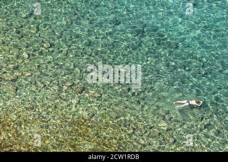 Naked Woman Swimming And Diving In The Mediterranean Sea Off The Coast