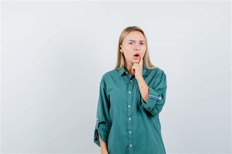 Fille Blonde Mettant L index Près De La Bouche Tout En Ouvrant La Bouche En Blouse Verte Et L