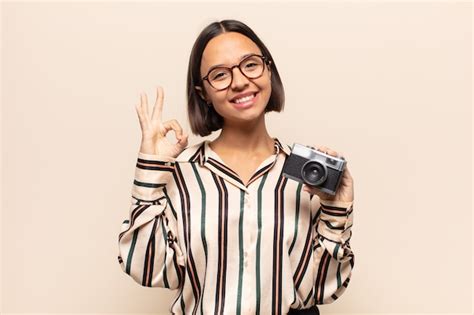 Mujer latina joven que se siente feliz relajada y satisfecha mostrando aprobación con gesto