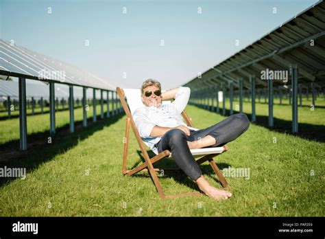 Mature Man Sitting In Beach Lounger Solar Plant Stock Photo Alamy