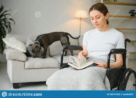 Mujer En Silla De Ruedas Leyendo Libro En Casa Foto De Archivo Imagen