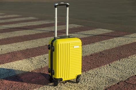 Premium Photo | Small yellow suitcase on road in the city