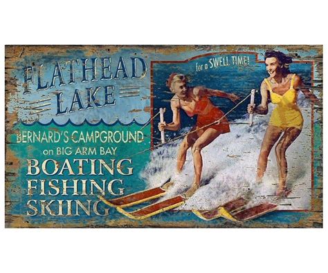 Two Women On Skis In Front Of A Sign That Says Boating Fishing Skiing