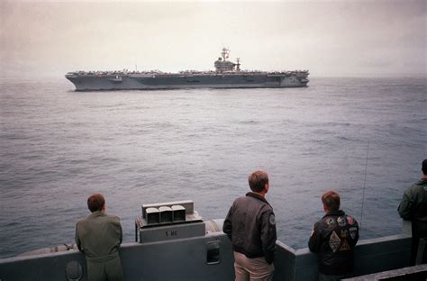 Crew Members Aboard The Aircraft Carrier USS FORRESTAL CV 59 Observe