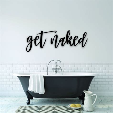 A Bath Tub Sitting Next To A White Wall With The Words Get Naked On It