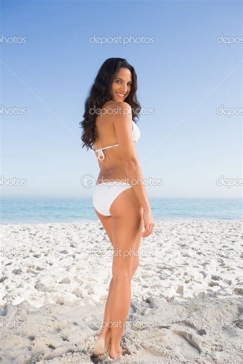 Smiling Attractive Dark Haired Woman Posing In White Bikini Stock Photo Wavebreakmedia