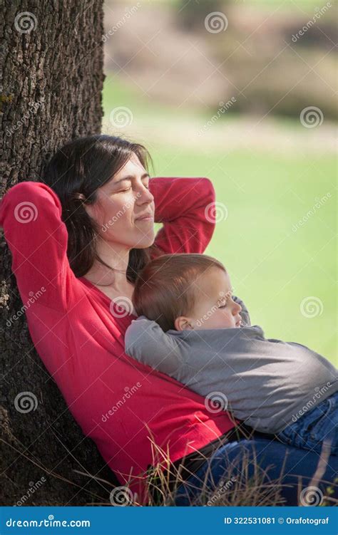 Mother And Son Sleep In The Shade Of A Tree Leaning Against The Trunk Stock Image Image Of