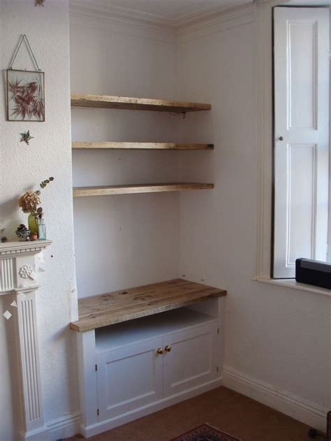 An Empty Room With Some Shelves And A Radiator Next To The Window In It