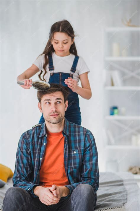Concepto para el día del padre con hija cortando pelo del padre | Foto