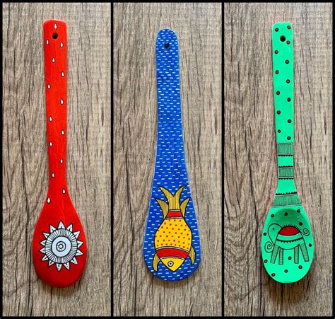 Three Colorful Spoons With Designs On Them Sitting Next To Each Other