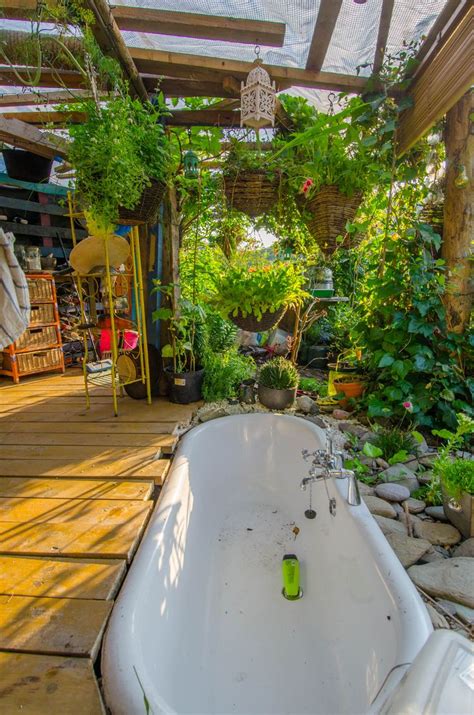 An Old Bathtub Sitting In The Middle Of A Garden With Lots Of Greenery