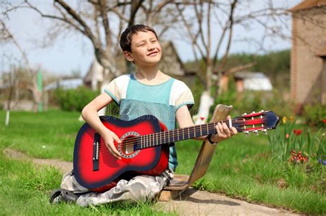 Muchacho Que Toca La Guitarra Al Aire Libre Foto De Archivo Imagen De