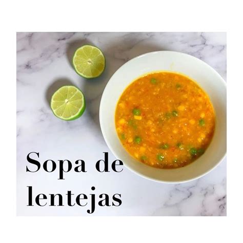 A White Bowl Filled With Soup Next To Two Limes