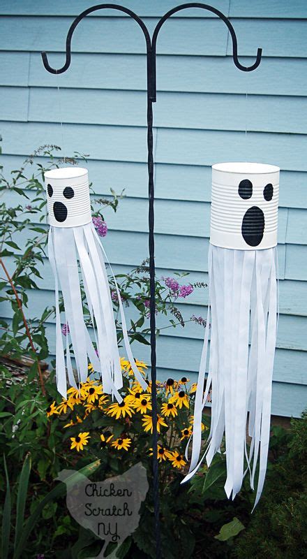 Two Paper Cups With Faces On Them Sitting In Front Of A Flower Pot