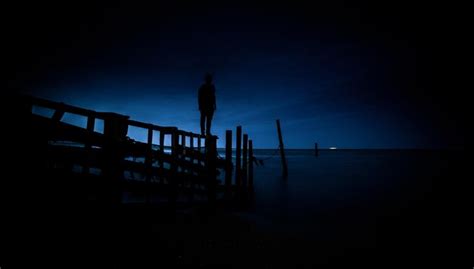 Premium Photo Low Angle View Of Silhouette Man Standing On Pier At Dusk