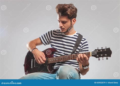 Pose De Guitariste Posée Dans Le Studio Tout En Jouant La Guitare Image