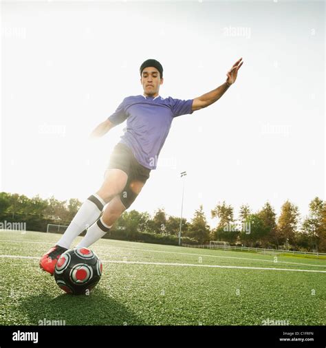 Mixed Race Soccer Player Kicking Soccer Ball Stock Photo Alamy