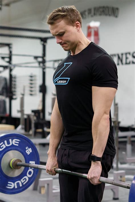 A Man Holding A Barbell In A Gym