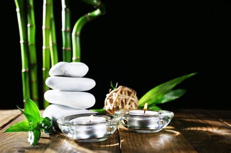 Hermosa composición con piedras de spa y velas en la mesa sobre fondo