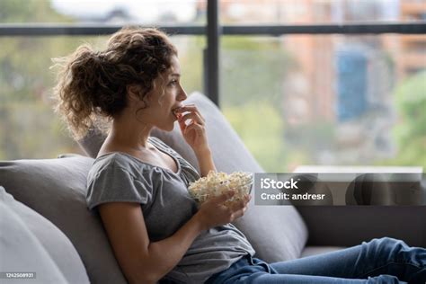 Woman In Quarantine Eating Pop Corn While Watching Television Stock