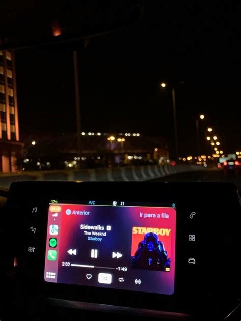 An Electronic Device Sitting On The Dashboard Of A Car In The Dark With