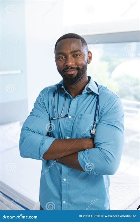 Portrait Of Happy African American Male Doctor Wearing Blue Shirt And