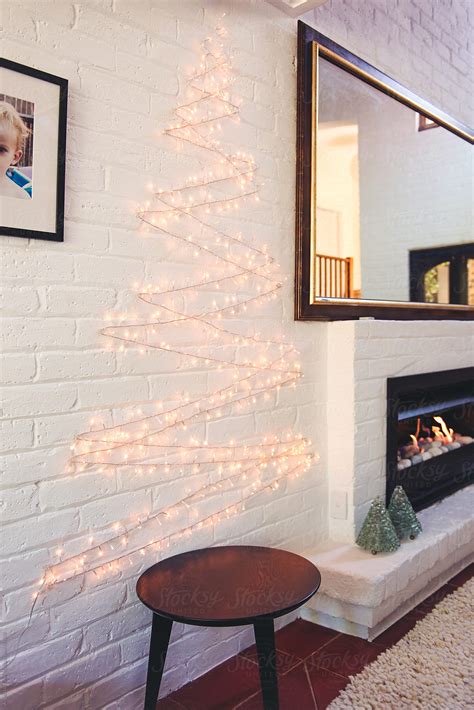 Holiday Lights In The Shape Of A Christmas Tree On A White Brick Wall