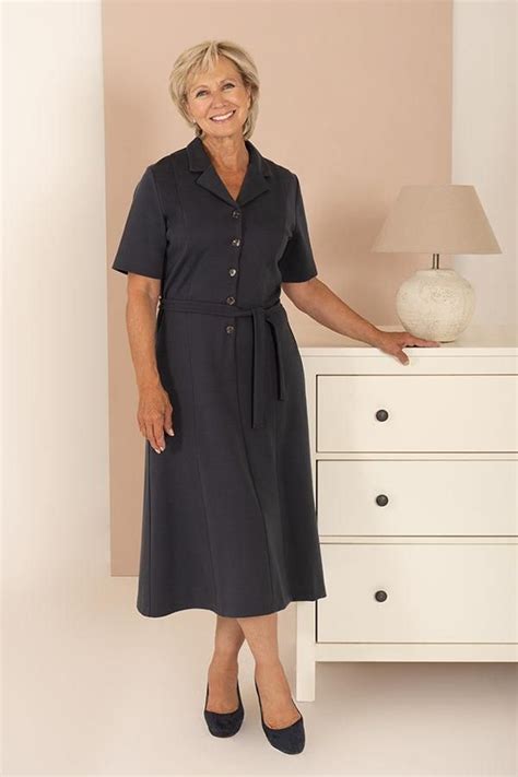 A Woman Standing Next To A White Dresser