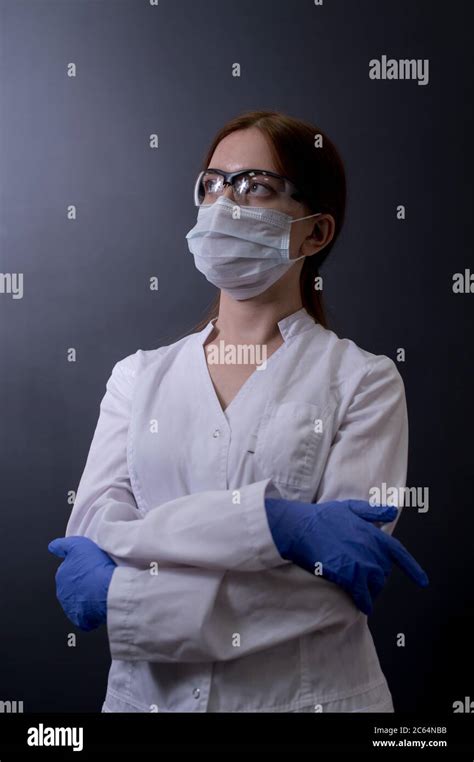 Female Doctor Or Nurse Wearing Scrubs Protective Face Mask And Goggles