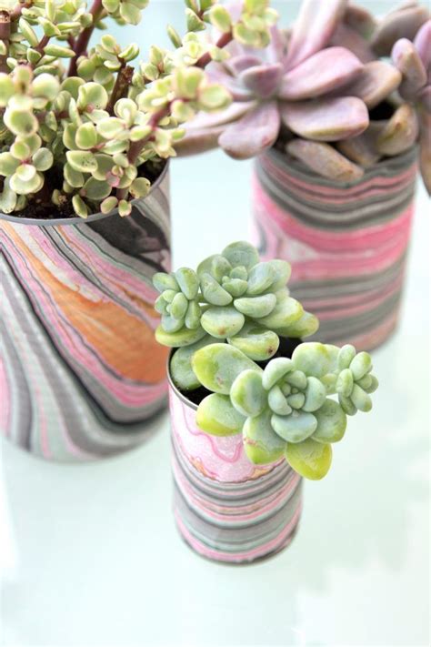 Three Vases With Plants In Them Sitting On A Table Next To Eachother