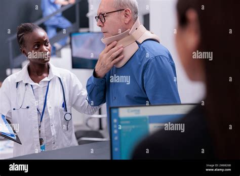 Paciente anciano con cuello explicando los síntomas al médico en el