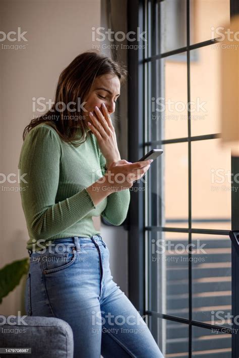 Young Woman Covering Her Mouth While Laughing At Funny Memes Stock