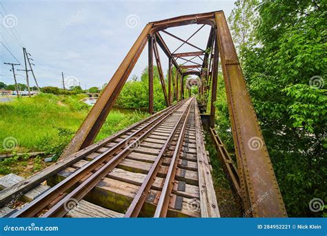 Old Rusty Truss Bridge With Moving Freight Train Over The Red Ri