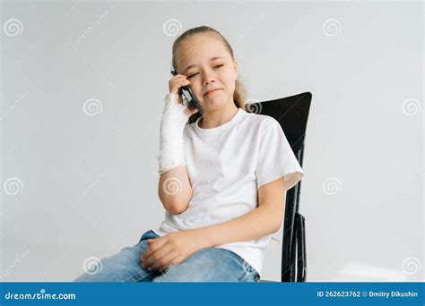 Portrait Of Cute Blonde Little Girl With Broken Arm Wrapped In Plaster