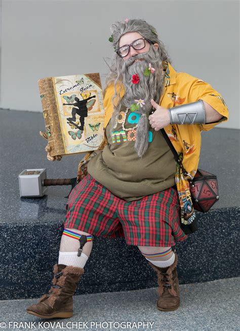 A Man Dressed As An Old Wizard Sitting On A Bench With A Book In His Hand