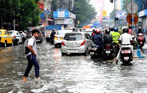 A Person Wade Through A Waterlogged Road After Heavy Rainfall