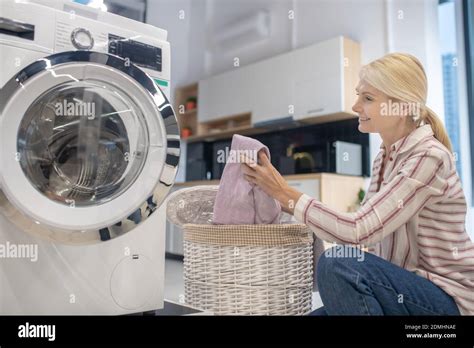 Blonde Housewife Putting Clothes Into Washing Machine Stock Photo Alamy