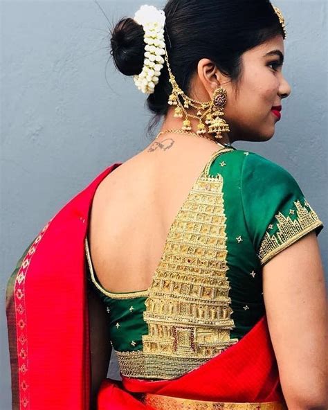 A Woman In A Red And Green Sari With Gold Accents On Her Back Looking Off To The Side