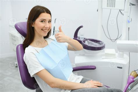 The girl is at the reception at the dentist. A happy client at the