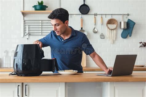 Homem Bonito Parado à Mesa Da Cozinha E Cozinhando Pão De Torrada