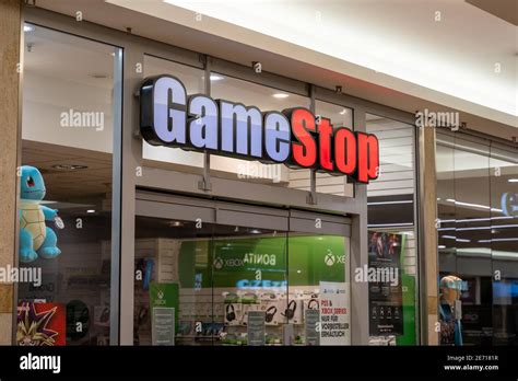 GameStop store front in a shopping center. Big illuminated logo shining ...