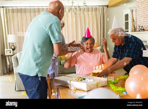 Happy Group Of Diverse Senior Friends Celebrating Birthday With Cake