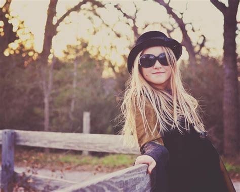 Premium Photo Beautiful Smiling Woman Wearing Sunglasses By Fence Against Trees