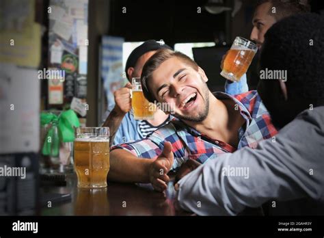 Young men drinking beer in pub Stock Photo - Alamy