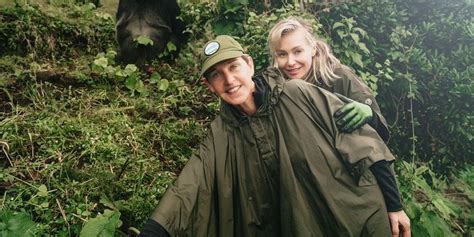 A Man And Woman Standing Next To Each Other In Front Of A Black Bear