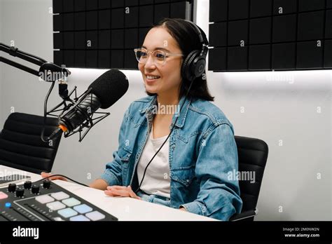 Beautiful Happy Young Female Radio Host Using Microphone And Headphones